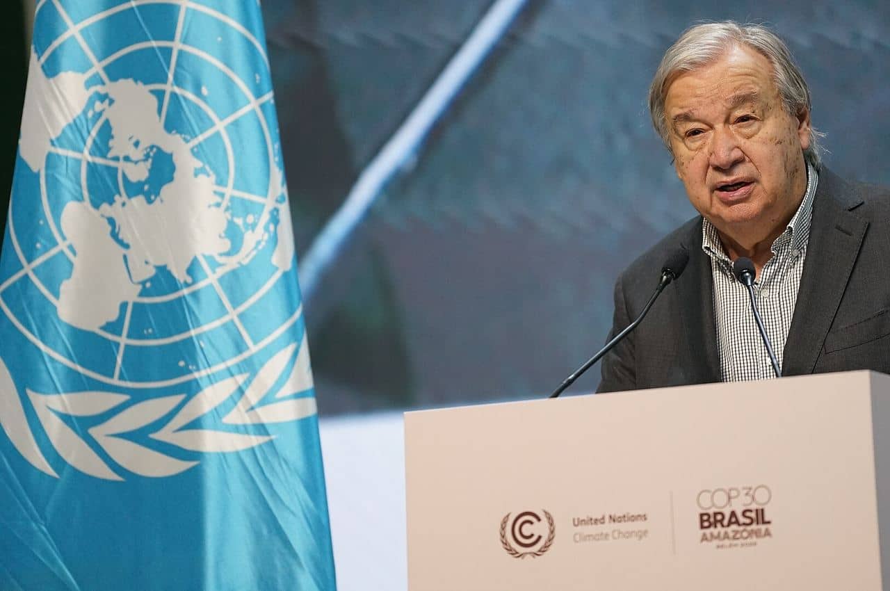UN Secretary-General António Guterres speaking at a podium beside a United Nations flag