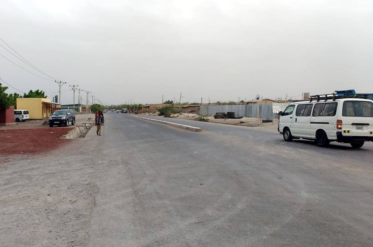 The main road through Asaita, a town in Ethiopia's Afar region, with a minibus and pedestrians
